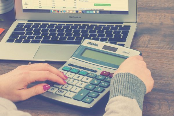 surviving your first sales tax audit - woman at desk with calculator and laptop
