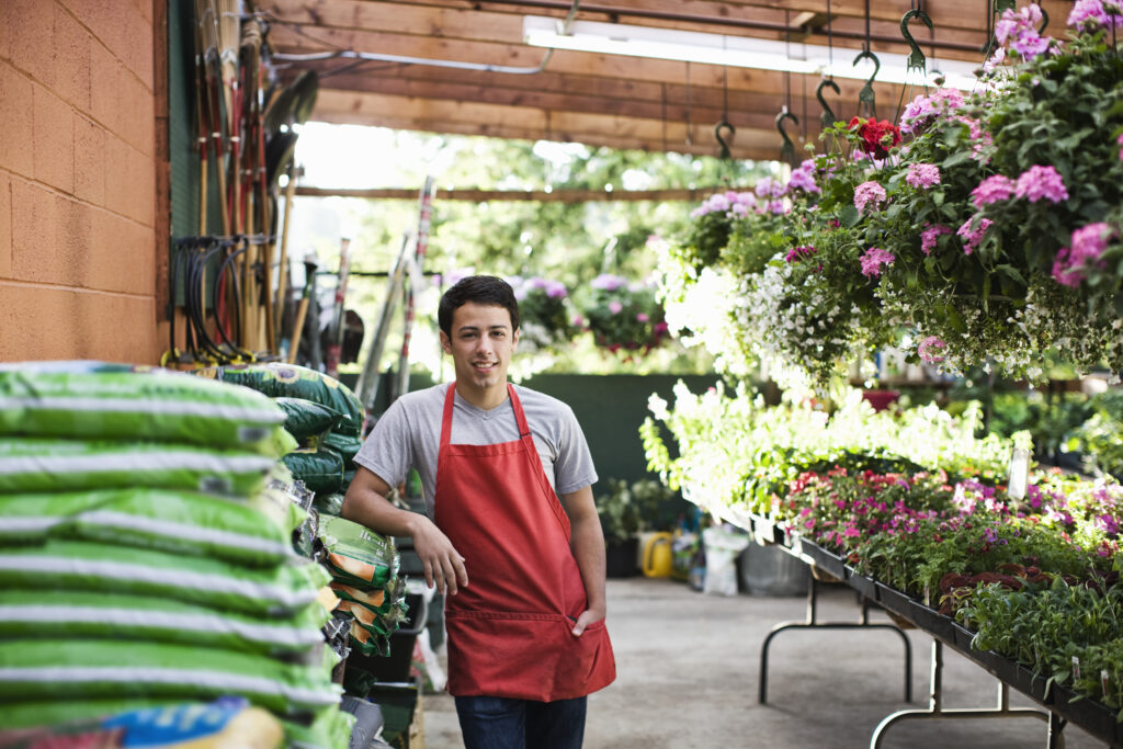 Garden Centre staff member helping customer choose compost when learning how to grow potatoes