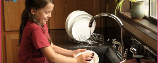 young girl washing dishes - age appropriate chores for children